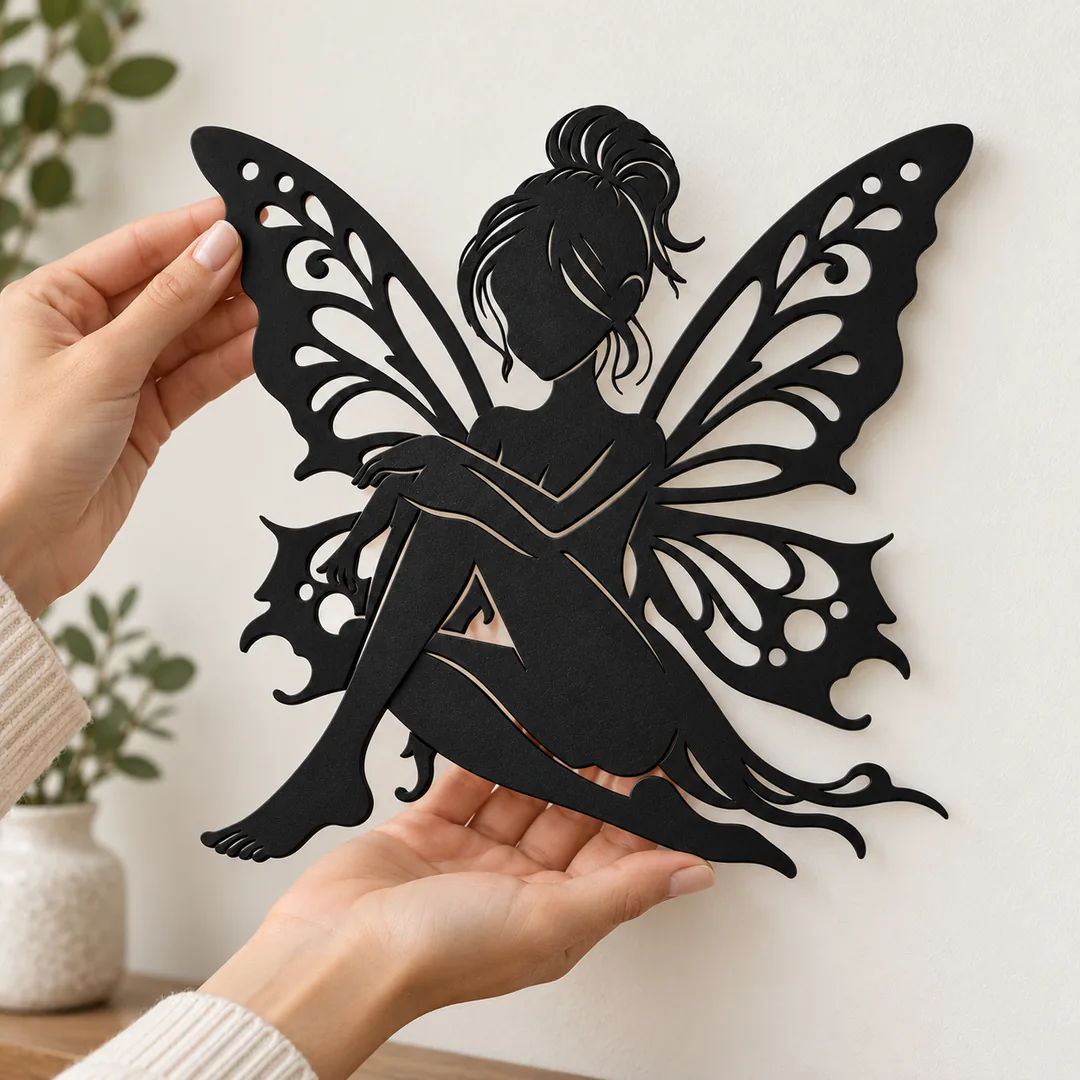 Décoration murale fée aux ailes de papillon noir mat tenue dans des mains pour illustrer son format de 23 cm