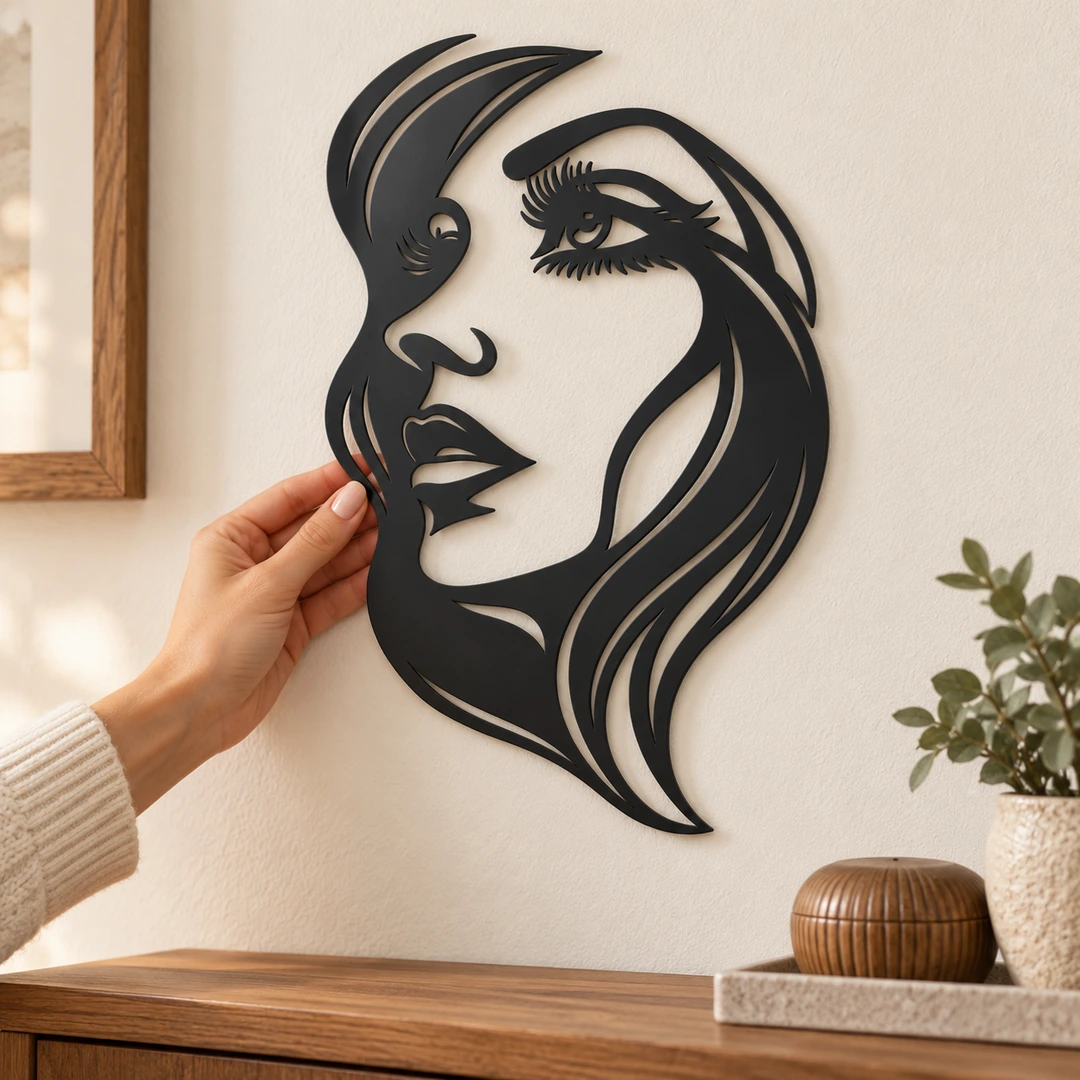 Décoration murale visage féminin présentée à côté d’une main pour l’échelle